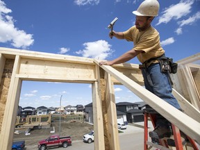 Orry Cherneski of OJS Home Solutions  hammers nails on the roof of a new home build in the neighbourhood of Aspen Ridge in Saskatoon, SK on Tuesday, June 5, 2018.