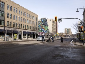 People cross the intersection of 21st Street East and 3rd Avenue South in Saskatoon, SK on Wednesday, March 25, 2020.