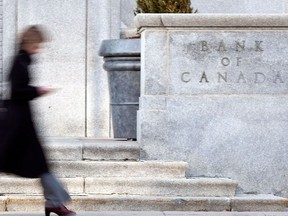 (FILES)A woman walks past the Bank of Canada building in Ottawa on April 12, 2011. - Canada's central bank on March 4, 2020 cut its key lending rate by 50 basis points to 1.25 percent in response to the growing economic risk posed by the coronavirus epidemic. The interest rate drop was the first in Canada since mid-2015, and followed a similar move by the US Federal Reserve on Tuesday. (Photo by GEOFF ROBINS / AFP)