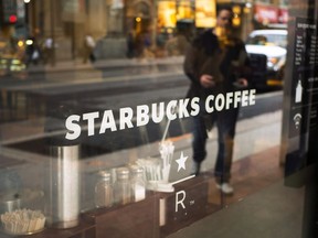 The front window of a downtown Starbucks Coffee store is shown in Toronto, May 10, 2018. Starbucks is stopping the use of reuseable cups and is halting business travel to combat the spread of the novel coronavirus.