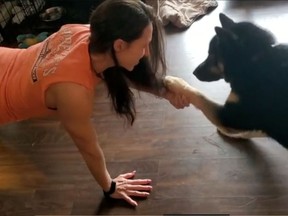 Debra Coutts does pushups with her dog in Saskatoon during the COVID-19 crisis.