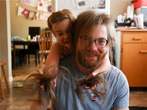 Thomas Roebuck lets his four-year-old daughter, Isabel, cut his hair after 35 days of social distancing.