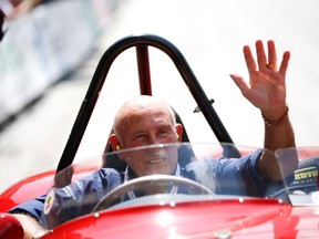 Former English Formula One driver Stirling Moss waves to spectators as he sits in his 1955 Ferrari 750 Monza during the Ennstal Classic rally near the Austrian village of Groebming.