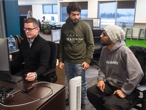 GasBuddy employees Michael Ferguson, left, Manas Prasher, centre, and Stanley Gomes work in the GasBuddy office on Research Drive in Regina, Saskatchewan on Dec. 13, 2019.