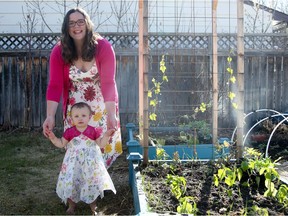 Kristen Raney, local garden blogger behind shifting roots, is pictured in her backyard with her daughter Aulaire.