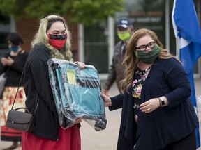 Dakota Gamble Morin receives a sewing machine case from Metis Nation-Saskatchewan (MN-S) Health Minister Marg Friesen. MN-S donated sewing machines and equipment to the Masked Makers, a group of 16 seamstresses.