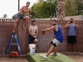 MLB pitcher Jakob Junis with the Kansas City Royals throws a pitch from a makeshift mound in front of Seth Blair with the San Diego Padres, trainer Seth Lintz and Danny Hultzen with the Chicago Cubs during a back yard training session on June 05, 2020 in Scottsdale, Arizona. Since the MLB season was paused indefinitely due to the coronavirus COVID-19 pandemic, players have been using the back yard at Seth Blairs' house to train and work on mechanics.