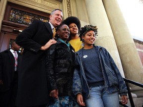 New York Democratic mayoral candidate Bill de Blasio poses with his family, wife Chirlane McCray, son Dante de Blasio and daughter Chiara de Blasio after voting at a public library branch on Election Day on November 5, 2013 in the Brooklyn borough of New York City.