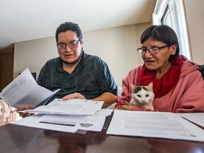 Jonathan, left, and his mother Mary-Ann McLeod look over documents regarding their claim against their former landlord, Jack Grover. They are still waiting for payment.