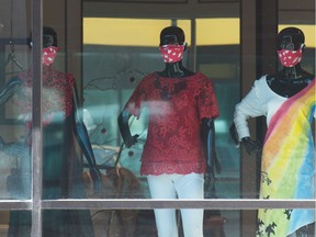 Mannequins are displayed wearing masks in the window of the Dean Renwick design studio on 12th Avenue in Regina, Saskatchewan on July 16, 2020.