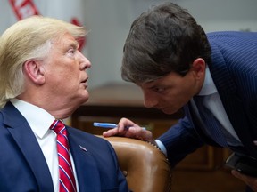 US President Donald Trump speaks with Hogan Gidley (R), White House Principal Deputy Press Secretary, during a meeting on the opioid epidemic in the Roosevelt Room of the White House in Washington, DC, June 12, 2019.