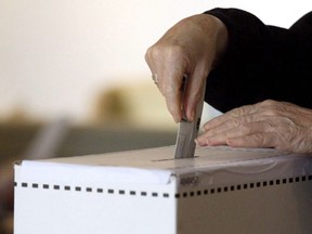 A woman casts her vote for the federal election in a polling station on Toronto's Ward Island on Monday, May 2, 2011. Elections Saskatchewan estimates it will need 400,000 face masks and thousands of litres of hand santizer and disinfectant to keep people safe at the polls this fall.