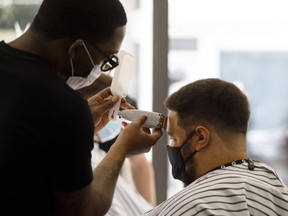 A stylist cuts a customer's hair at a barbershop in Toronto, Ontario, Canada, on Wednesday, June 24, 2020.