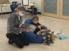 An instructor wearing a mask helps a child during the summer reading camp held during the COVID-19 pandemic. Photo submitted by Nicola Bishop-Yong.