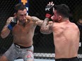 In this handout image provided by UFC, Frankie Edgar, left, punches Pedro Munhoz of Brazil in their bantamweight fight during the UFC Fight Night event at UFC APEX on Aug. 22, 2020 in Las Vegas, Nevada.
