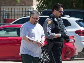 Edward Genaille, left, is seen in custody after appearing for sentencing following his being convicted of manslaughter in the killing of Daniel DiPaolo. He is pictured here outside Court of Queen's Bench in Regina on July 14, 2020.