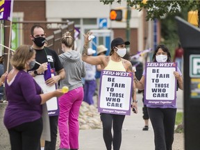 SEIU-West members hold signs and wave to cars outside St. Paul's Hospital on Aug. 12, 2020.