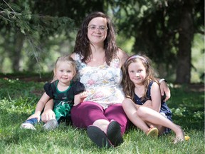Cecilia Prokop, centre, sits with her kids Evelyn Prokop, left, and Elizabeth Prokop, in Regina on Aug. 6, 2020. Cecilia is an organizer of the Mask Up For Education rally taking place Friday across the province, to protest the Saskatchewan's government's COVID-19 back-to-school plan.