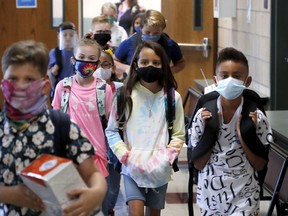 Wearing masks to prevent the spread of COVID19, elementary school students walk to classes to begin their school day in Godley, Texas, Wednesday, Aug. 5, 2020. Nearly all Saskatchewan school divisions will require masks this fall, despite the provincial government refusing to bring in a mandate.