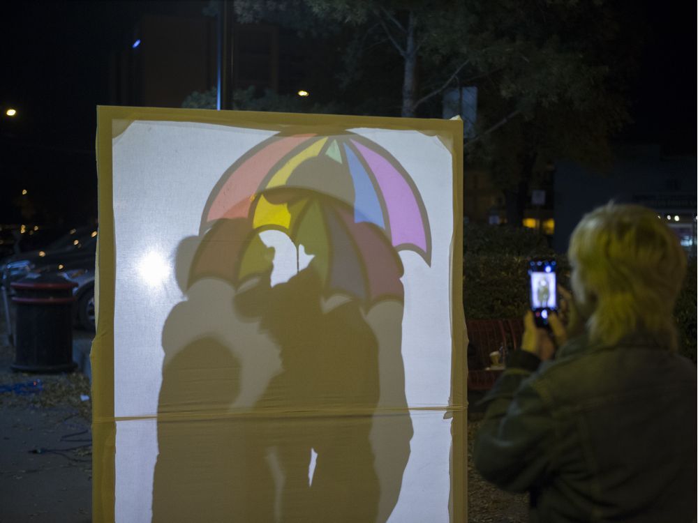 Avery Arseneau takes a photograph of attendees interacting with one of many art instillations during the Nuit Blanche art festival in Saskatoon, Sept. 30, 2017.