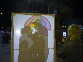 Avery Arseneau takes a photograph of attendees interacting with one of many art instillations during the Nuit Blanche art festival in Saskatoon, Sept. 30, 2017.