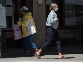 Two pedestrians wear masks in downtown Regina, Saskatchewan on July 28, 2020