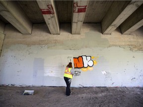 A graffiti tag is being power washed off a sound-barrier wall in Lawson Heights. Photo taken in Saskatoon, SK on Friday, September 4, 2020.