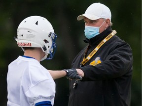 Saskatoon Hilltops head coach Tom Sargeant fist-pumps with one of his young football prospects during practice on Wednesday, September 9, 2020 at Ron Atchison Field.