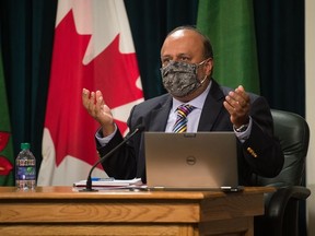 Saskatchewan's chief medical health officer Dr. Saqib Shahab, right, speaks to media regarding the COVID-19 pandemic during a news conference at the Saskatchewan Legislative Building in Regina, Saskatchewan on Sept. 17, 2020. Shahab is seen wearing a mask, which he briefly put on as he was speaking about mask usage.