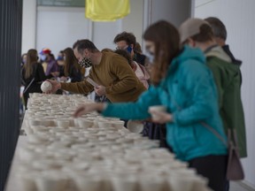 Attendees look at cups from the project Out of Place, by Nurgül Rodriguez.