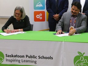 Saskatoon Public Schools' Board Chair Colleen MacPherson and Whitecap Dakota First Nation Chief Darcy Bear sign an 
agreement supporting their ongoing education partnership.