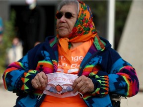 Maria Linklater wears an orange shirt and mask that reads "every child matters" to raise awareness of the devastating impact of the residential school system on Indigenous people.