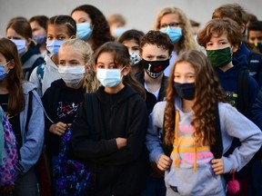 Pupils wearing protective masks stand as they listen to a woman (unseen) at Françoise-Giroud middle school in Vincennes, east of Paris, on September 1, 2020.