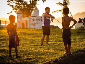 Jon Jon Rivero, centre, demonstrates a martial arts move to two children during one of his trips to the Philippines while filming his documentary Balikbayan: From Victims to Survivors. The documentary premieres at the Edmonton International Film Festival on Oct. 7, 2020.