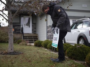 Charlie Clark installs a lawn sign while canvassing in October. Clark is seeking a second term in the mayor's chair on Nov. 9.