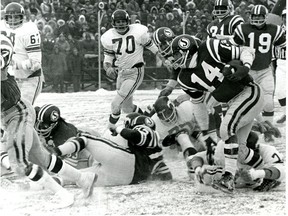Saskatchewan Roughriders quarterback Gary Lane, 14, runs the ball against the Calgary Stampeders in Game 3 of the 1970 Western Conference final at a snow-swept Taylor Field.