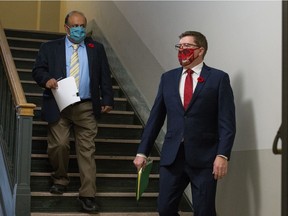 Saskatchewan premier Scott Moe, right, walks toward the radio room prior to a news conference at the Saskatchewan Legislative Building in Regina on Nov. 3, 2020. He is followed by Saskatchewan's chief medical health officer Dr. Saqib Shahab, left.