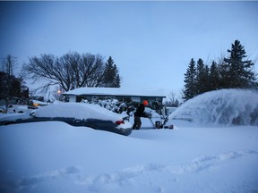 Saskatoon residents clear their sidewalks after a record-breaking snow fall on Monday November 9, 2020.