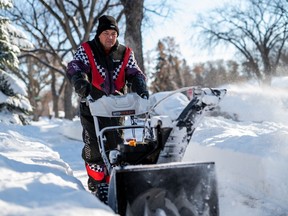 Rob Dembrowski gets his snowblower underway to clear his neighbours' sidewalks after a heavy snowfall kept roads impassable Nov. 9.