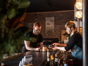 Thayne, left, and Beth Robstad tie ribbon onto take-out jars of eggnog and rum at their restaurant Hearth.