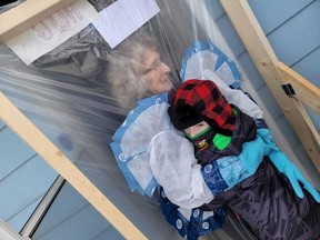 Louella MacDonald hugs great-grandson Sean Scharfstein-McGettigan through a plastic-lined "hugging station" built to keep her safe during the COVID-19 pandemic.