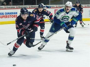 Regina Pats forward Carter Chorney (22) carries the puck while being pursued by Cole Nagy (38) of the Swift Current Broncos during WHL action at the Brandt Centre on Saturday.