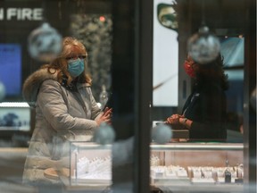 A masked customer shops through a window in downtown Saskatoon on Dec. 11, 2020.