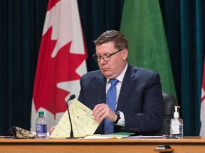 Saskatchewan Premier Scott Moe goes over his notes during a news conference, regarding COVID-19, held at the Saskatchewan Legislative Building in Regina, Saskatchewan on Jan. 19, 2021.