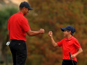 Tiger Woods of the United States and son Charlie Woods fist bump on the 18th hole during the final round of the PNC Championship at the Ritz Carlton Golf Club on Dec. 20, 2020 in Orlando, Fla.