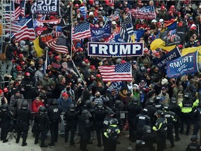 Police hold back supporters of US President Donald Trump as they gather outside the US Capitol's Rotunda on January 6, 2021, in Washington, DC. - Demonstrators breeched security and entered the Capitol as Congress debated the a 2020 presidential election Electoral Vote Certification.