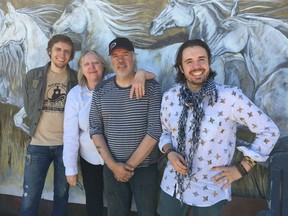 Connie Kaldor and Paul Campagne (centre) with their sons Aleksi Campagne (left) and Gabriel Campagne (right) pose for a photo, in front of a mural by artist Debora Cardaci, at the Campagne family farm near Willow Bunch, Sask., on July 26, 2019.