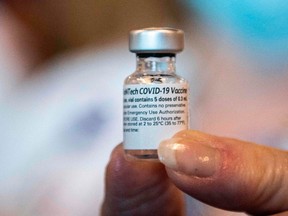 In this file photo a healthcare worker holds a Pfizer-BioNtech Covid-19 vaccine at Memorial Healthcare System, in Miramar, Florida on December 14, 2020.