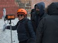 Agam Darshi (left), lead actor, director and writer for the film Donkeyhead, and first assistant director Jason Bohn, watch a monitor to review a scene on the film's set near Rose Street and 14th Avenue in Regina on Jan. 22, 2021.