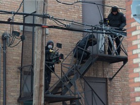 A camera crew for the film Donkeyhead sets up equipment on the fire escape of a building on the film's set near Rose Street and 14th Avenue in Regina on Jan. 22, 2021.